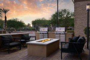 a patio with a fire pit with chairs and a bar at TownePlace Suites by Marriott Phoenix Chandler/Fashion Center in Chandler