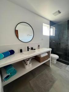 une salle de bain blanche avec un lavabo et un miroir dans l'établissement New 2 Bedroom Huge Beachfront Patio in San Pedro Town, à San Pedro 30 autres photos