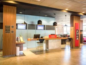 un hall d'entrée avec un bureau sur lequel se trouve un ordinateur portable dans l'établissement ibis Catanduva, à Catanduva