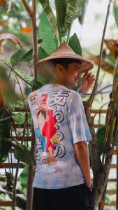 a young man wearing a hat standing in a tree at O-ya Homestay in General Luna +8 photos