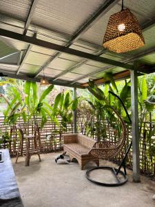 a patio with a bench and chairs and plants at O-ya Homestay in General Luna