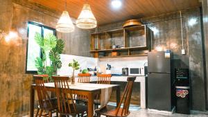 a kitchen with a table with chairs and a refrigerator at O-ya Homestay in General Luna