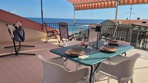 Una mesa y sillas en un balcón con vista al mar. en Lumeriam Sea Loft, en Roccalumera