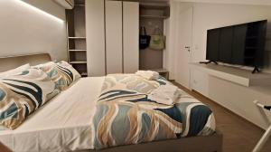 Un dormitorio con una cama y un televisor de pantalla plana. en Lumeriam Sea Loft, en Roccalumera