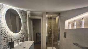 Un baño con ducha, lavabo y espejo. en Lumeriam Sea Loft, en Roccalumera