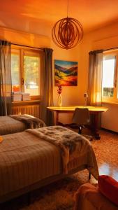 a bedroom with two beds and a table and windows at Villa dei Pini in Laveno-Mombello