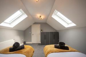 2 Betten in einem Dachzimmer mit Oberlichtern in der Unterkunft Contractor & Professional Friendly House in Sleaford