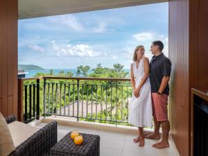 un homme et une femme debout sur un balcon dans l'établissement Novotel Phuket Kata Avista Resort and Spa, à Kata Beach
