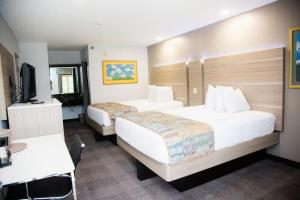 a hotel room with two beds and a television at Townhouse Fort Walton Beach Hurlburt Field in Mary Esther