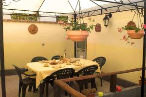 a table in a room with chairs and plants at I Colori Del Sole in Fiumefreddo di Sicilia