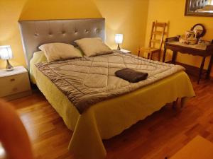 a large bed in a bedroom with two lamps at chambre dans une maison in Chassagnes