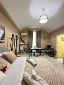a bedroom with a large bed and a dining room at Ma Maison Etnea in Catania