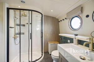 Un baño con ducha, inodoro y lavabo. en The Pemberley - Luxury 2 Bed Houseboat, en Londres