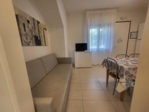 ein Wohnzimmer mit Sofa und Tisch in der Unterkunft Residence Equilio Family Apartments in Lido di Jesolo