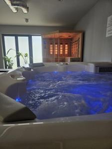 ein Whirlpool mit blauem Wasser in einem Zimmer in der Unterkunft Stay4U Apartments Belle View in Szklarska Poręba