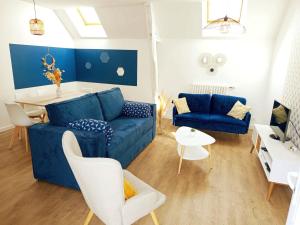 a living room with a blue couch and a table at Escapade, T3 Proche gare in Cholet