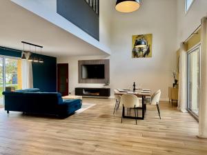 un salon avec un canapé bleu et une table dans l'établissement VillasHomeClet - Villa Côte & Lac, à Naujac-sur-Mer