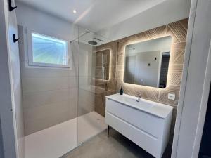 une salle de bain avec un lavabo blanc et une douche dans l'établissement VillasHomeClet - Villa Côte & Lac, à Naujac-sur-Mer