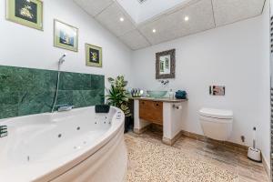 a bathroom with a tub and a toilet and a sink at Magnificent Getaway - Tennis, Climbing & More! in Backwell