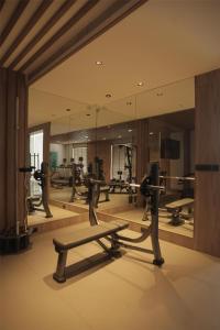 ein Fitnessstudio mit einer Reihe von Trainingsgeräten und einem Spiegel in der Unterkunft Radisson Resort Hatgad Saputara in Saputara