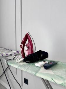 a iron and a remote control on a table at Action Djal in Bishkek