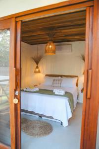 a bedroom with a bed and a door open at Villa Loui Beach Icaraizinho-Ce in Icaraí