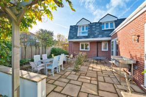 a patio with a table and chairs and a house at Magnificent Getaway - Tennis, Climbing & More! in Backwell +25 photos