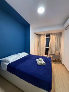 um quarto azul com uma cama com duas toalhas em Apartamento no Centro RJ - Rua do Theatro Municipal no Rio de Janeiro