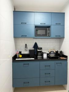 uma cozinha com armários azuis e um micro-ondas em Apartamento no Centro RJ - Rua do Theatro Municipal no Rio de Janeiro