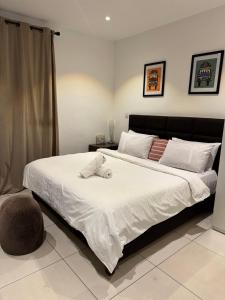 a bedroom with a large white bed with a chair at Luxury Sid Apartments in Accra