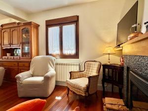 ein Wohnzimmer mit zwei Stühlen und einem Kamin in der Unterkunft Casa Sortalde Agroturismo in Abaurrea Alta