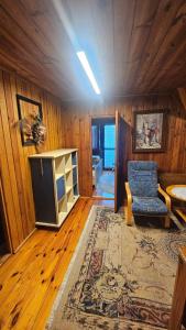 a living room with a blue chair and a rug at Magiczny Dom nad Bugiem 