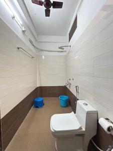 a bathroom with a toilet and a blue trash can at Lokosha Resort - The Green Destination in Hatikhuli