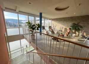 eine Gruppe von Personen, die in einem Zimmer mit großen Fenstern sitzen in der Unterkunft Landhotel Knappenberg in Ober-Gossen