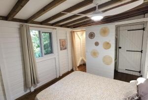 a bedroom with a bed and a window and a door at Kaz Coco Bungalow in Bouillante