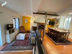 a living room with a couch and a dining room at Gîte La Chaumine in Brangues +28 photos