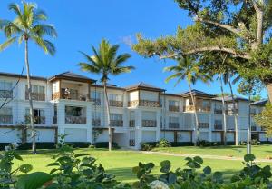 a large white building with palm trees in the foreground at Fortunity Club- Playa Dorada, Pto Plata in Sampiño