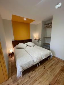 a bedroom with a bed and a yellow wall at Gîte La Chaumine in Brangues