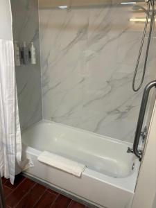 ein Badezimmer mit Dusche und weißer Badewanne in der Unterkunft Spark by Hilton Abingdon I-81 near Fairgrounds in Abingdon