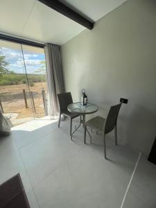 a dining room with a table and chairs and a window at Suítes Domo do Matto in Garanhuns