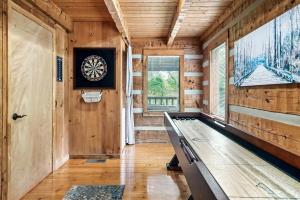a room with a ping pong table and a dartboard on the wall at Bluff Mountain's Private Retreat in Sevierville