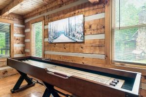 a piano in a room with wooden walls and windows at Bluff Mountain's Private Retreat in Sevierville