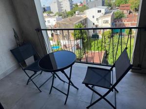Ein Tisch und zwei Stühle auf einem Balkon mit Aussicht in der Unterkunft Escobar Centro in Belén de Escobar