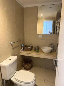 a bathroom with a white toilet and a sink at Escobar Centro in Belén de Escobar