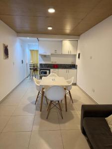 a living room with a table and a kitchen at Escobar Centro in Belén de Escobar