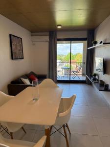 a table and chairs in a living room with a view at Escobar Centro in Belén de Escobar