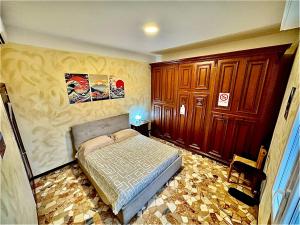 a bedroom with a bed and wooden cabinets at Eden Guesthouse in Bologna