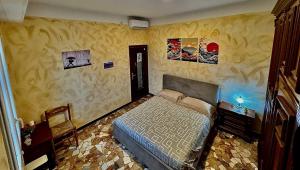 a bedroom with a bed and paintings on the walls at Eden Guesthouse in Bologna