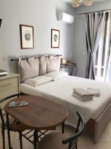 a bedroom with a large bed with a table and a table sidx sidx at Haplotēs Rhodes Studio in Koskinou
