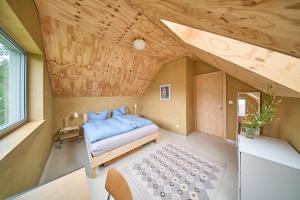 a bedroom with a bed and a wooden ceiling at Elegant holiday residence with privat sauna close to Baltic Sea on Wolin Island in Wisełka